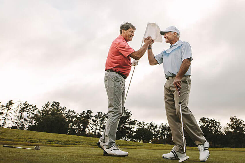 Two older men celebrating on golf course